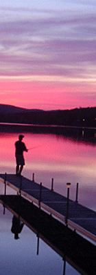 Photo of boy fishing from the dock while enjoying a beautiful sunset on Wallace Pond (also known as Lake Wallace, VT)