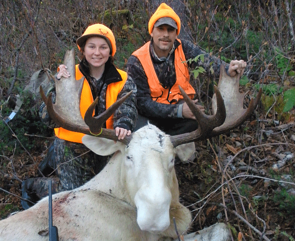 A happy and successful moose hunter who stayed at Jackson's Lodge poses with her uncle and an albino moose