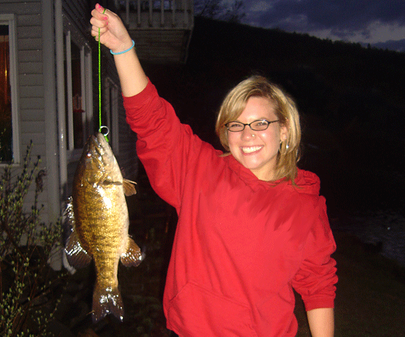 Photo of smiling girl after catching a nice fat bass in Wallace Pond located in Vermont's Northeast Kingdom (NEK).