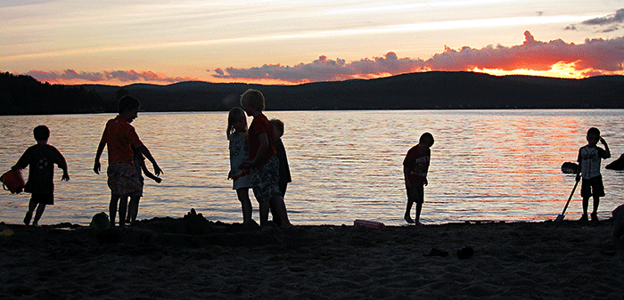 Kids playing on the sandy beach at Jackson's Lodge hoping their parents will let them stay up as long as possible