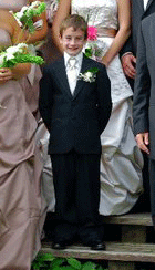 This smiling ring bearer takes center stage in a wedding party portrait taken on the steps at The Main Lodge - Sarah Sanville Photography - Click for larger image