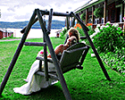 Newlyweds relax on a swing chair overlooking Lake Wallace (Wallace Pond) near The Main Lodge at Jackson's Lodge and Log Cabins in Vermont's Northeast Kingdom - Click for larger image