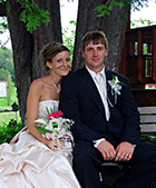 Newlyweds pose for wedding photos in the shade of a spruce tree near the farmer's porch at the Main Lodge - Sarah Sanville Photography - Click for larger image